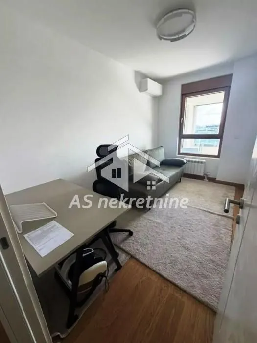 Small living room with a desk and seating furniture.