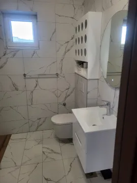 Savremeno opremljeno kupatilo sa belim keramičkim pločicama sa efektom mermera. - image 3