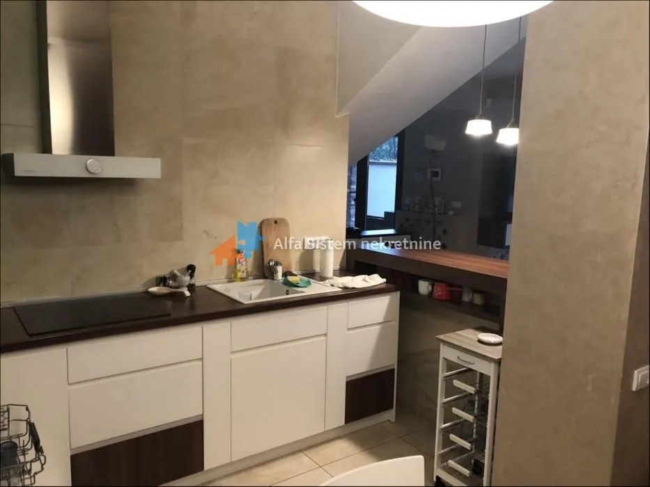 View of a modernly equipped kitchen with white cabinets and a breakfast bar.