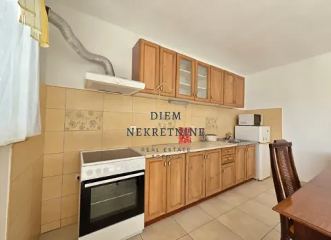 Traditional kitchen with wooden cabinets and a dining table. - image 11