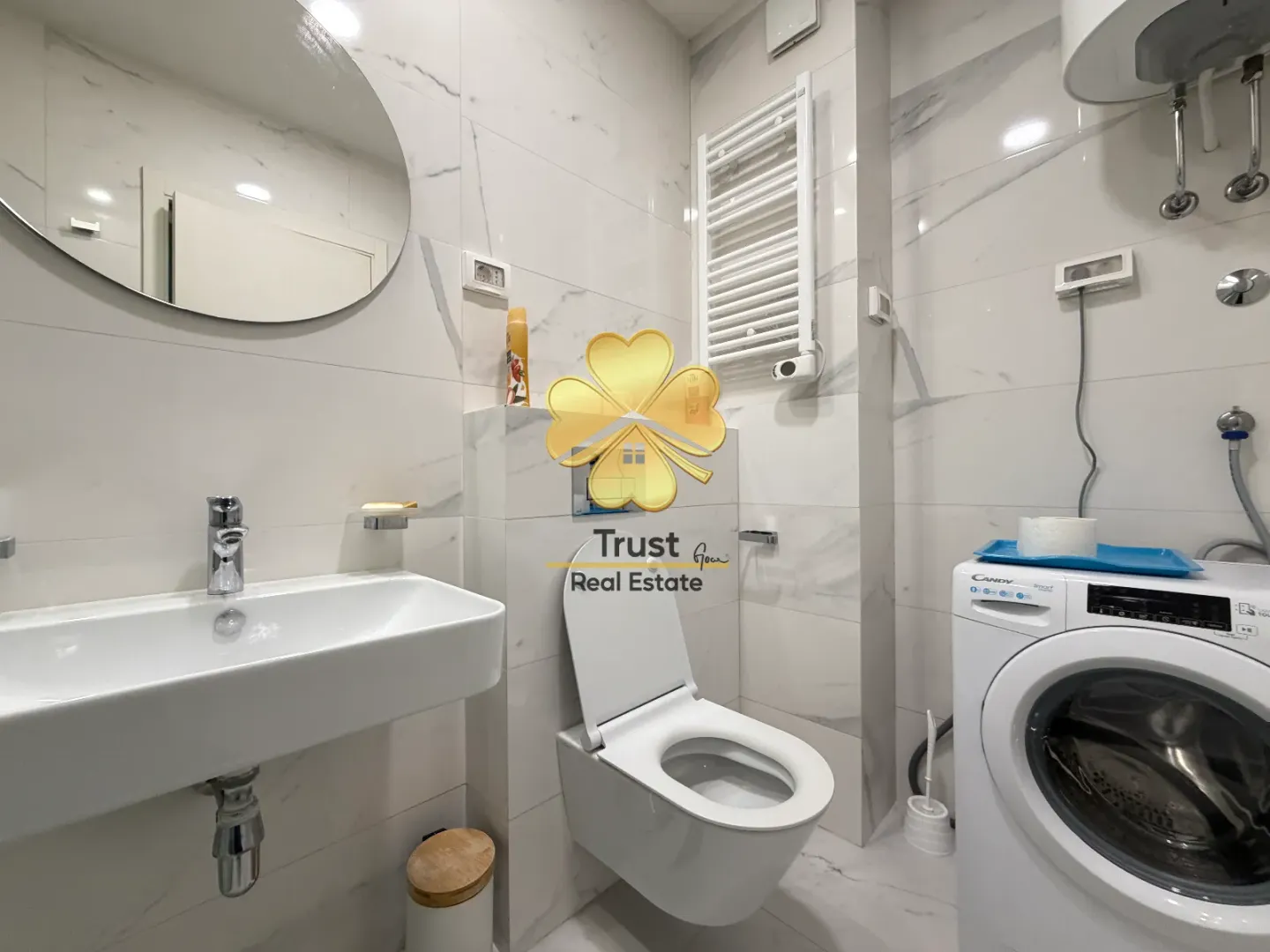 Moderne opremljeno kupatilo sa umivaonikom, wc šoljom i veš mašinom.