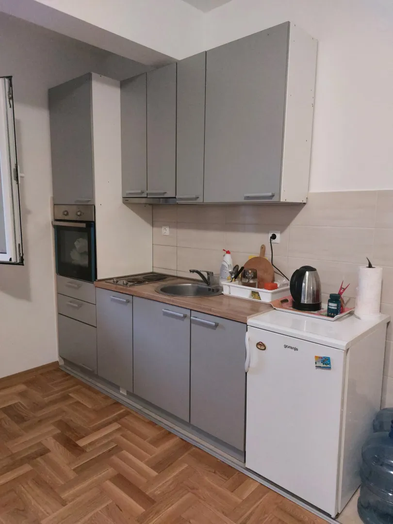 Small kitchen with grey cabinets and built-in appliances.