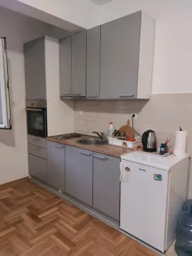 Small kitchen with grey cabinets and built-in appliances. - image 8