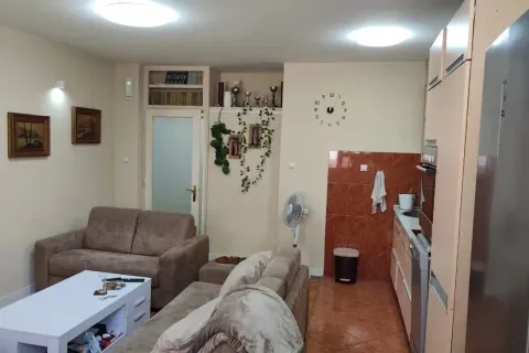 Dnevni boravak povezan sa kuhinjom, opremljen garniturom i stočićem. - image 4