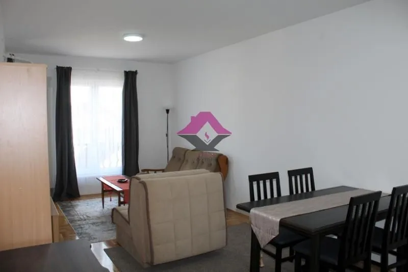 Living room with a sofa, armchair, and dining table.