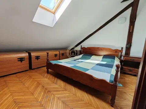Attic bedroom with a wooden bed and a skylight. - image 16