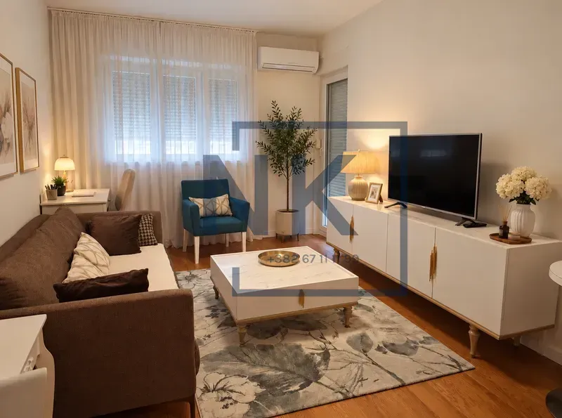 Namještena dnevna soba sa garniturom, televizorom i radnim stolom.