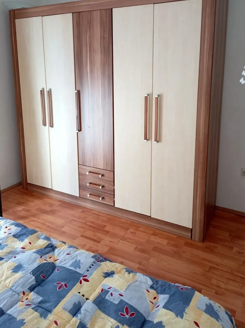 Bedroom with a large wooden wardrobe and a double bed.