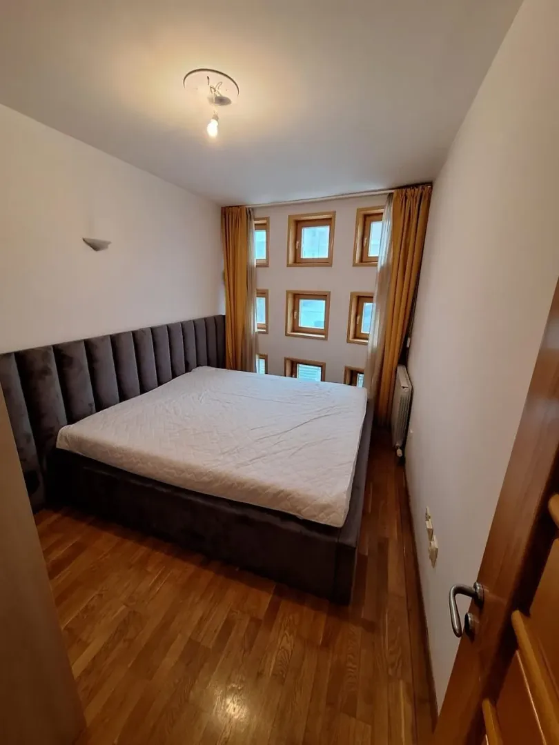 Spavaća soba sa bračnim krevetom i prozorima neobičnog rasporeda.