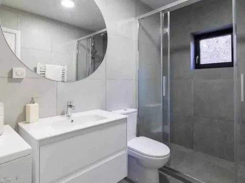 Svijetlo i moderno kupatilo sa tuš kabinom i bijelim lavaboom. - image 4