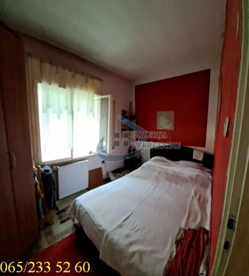 Manja spavaća soba sa krevetom i prozorom.