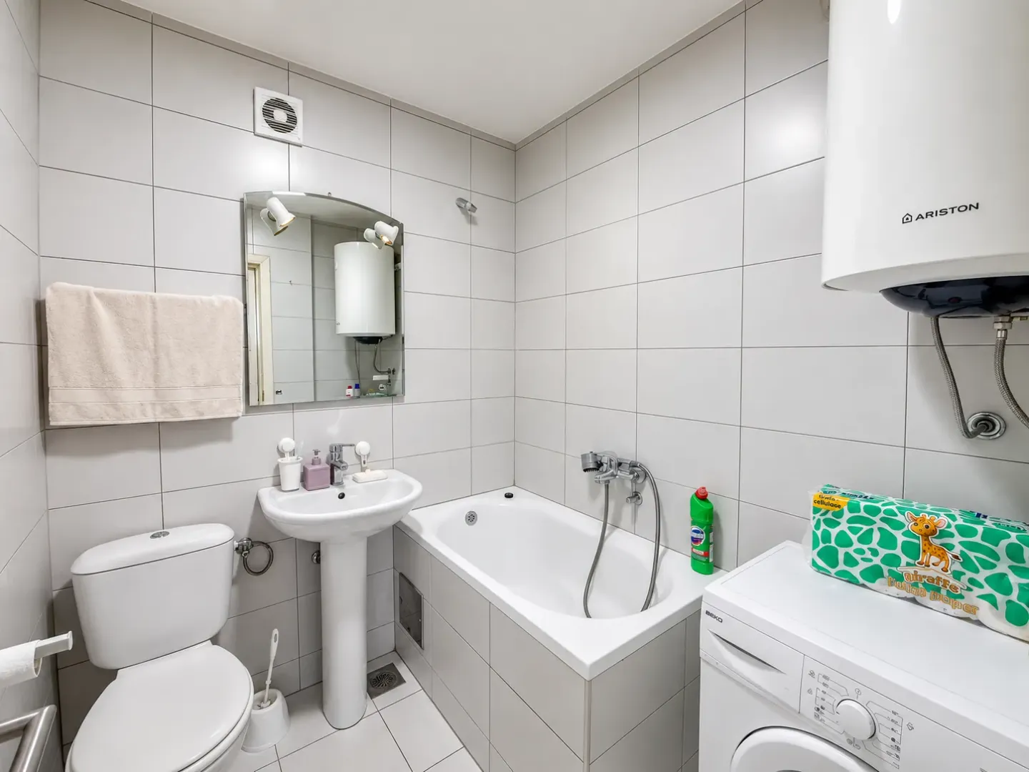 Bathroom equipped with a bathtub, washbasin, toilet, and washing machine.