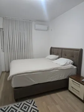 Svjetla spavaća soba sa bračnim krevetom, noćnim stočićem i klima uređajem. - image 6