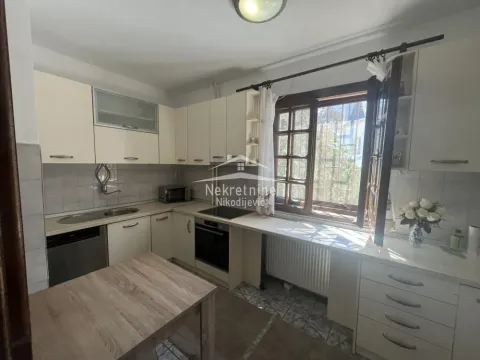 Small kitchen with white cabinets, stove, and a window. - image 11