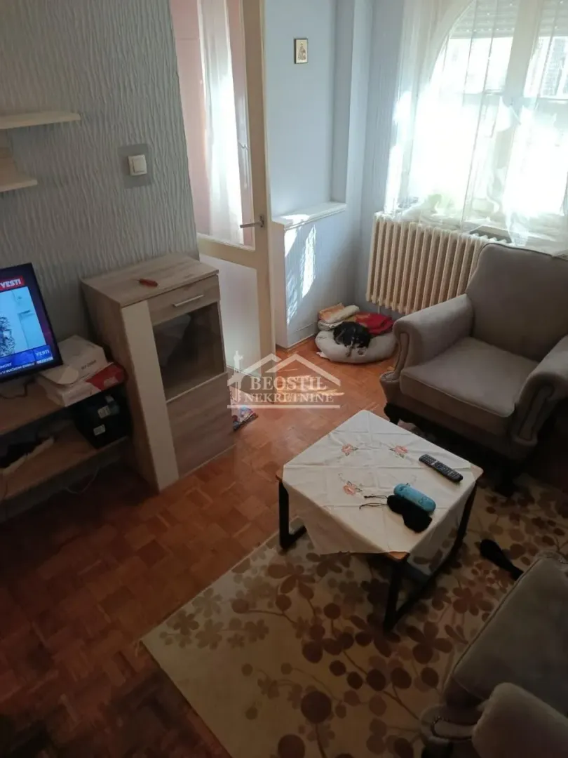 Smaller living room with armchairs, coffee table and television.