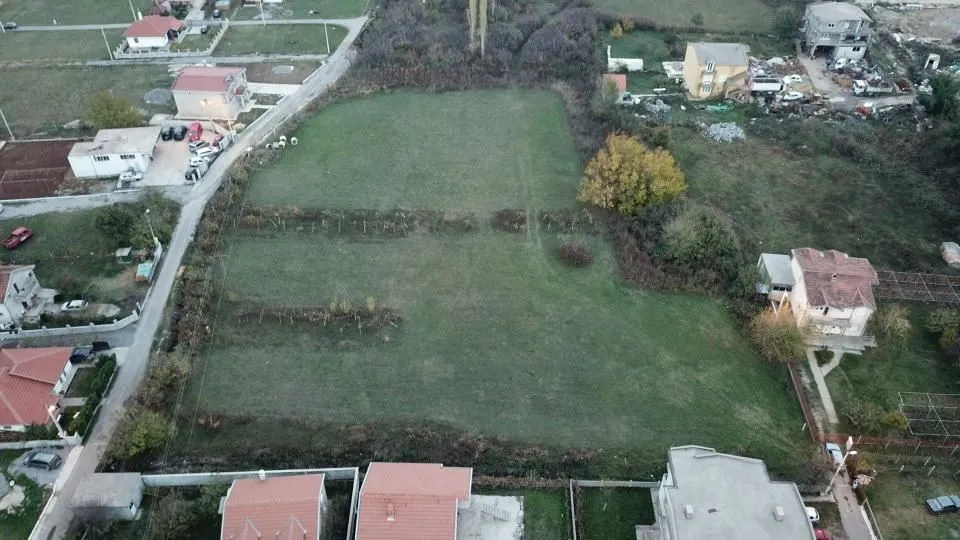 Pogled iz vazduha na prostrani ravni plac okružen kućama.