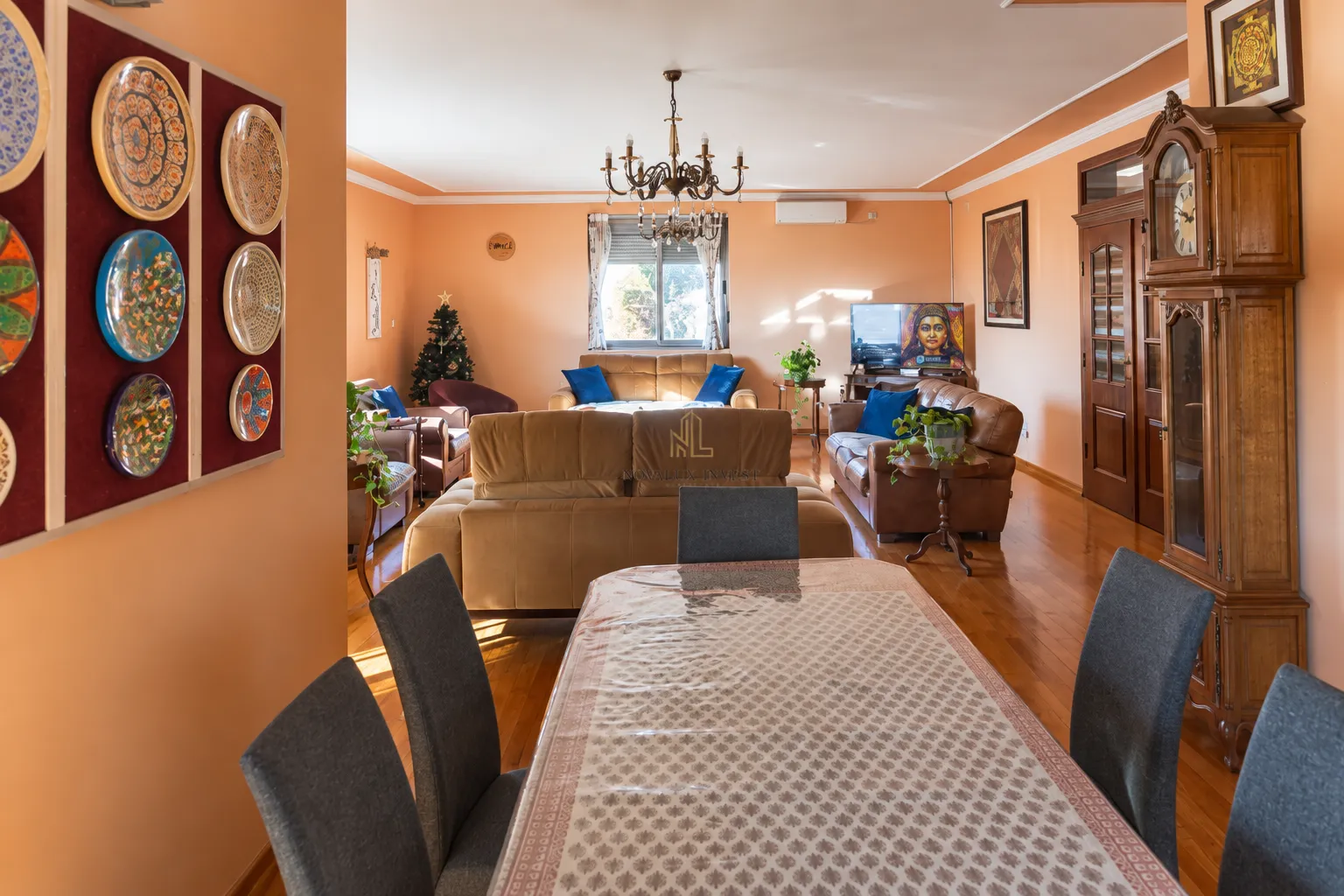 Spacious living room connected to the dining area, decorated with warm wall tones and traditional details.
