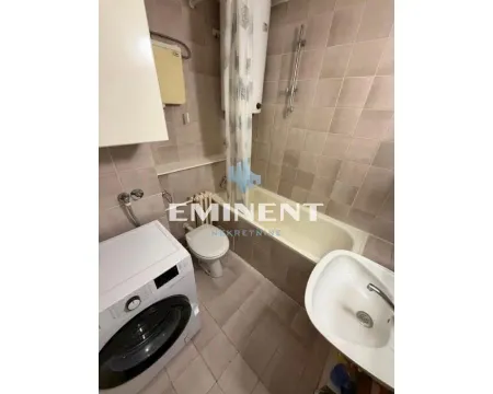 Smaller bathroom with a bathtub, washbasin, toilet, and washing machine. - image 15
