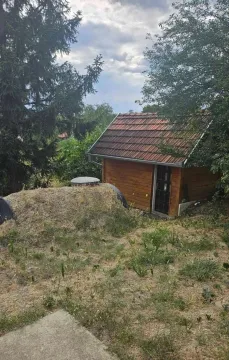 Manja drvena vikendica okružena zelenilom i drvećem. - image 4