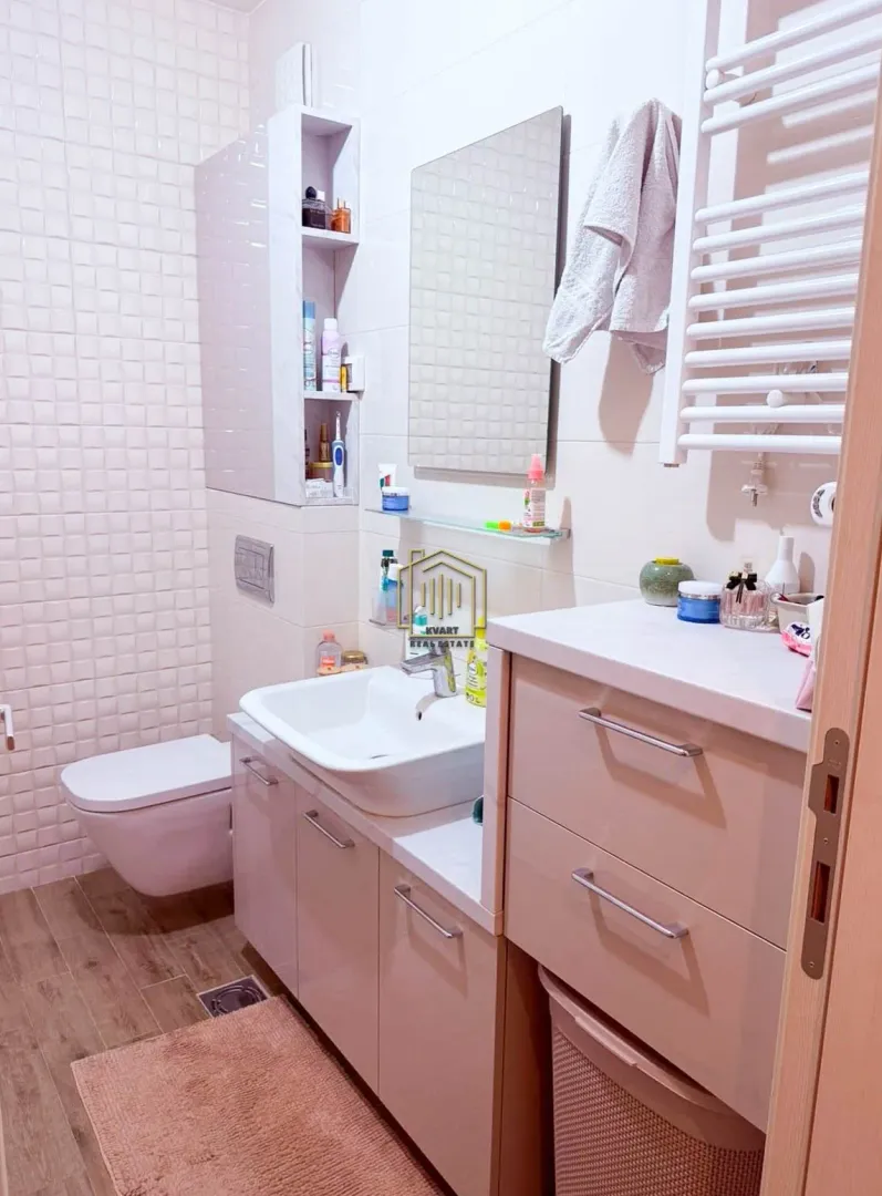 Compact bathroom with a sink, cabinet, mirror, and toilet bowl.