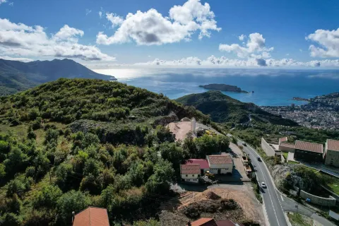 Pogled iz vazduha na brdoviti pejzaž, obalu i more sa ostrvom u daljini. - image 6
