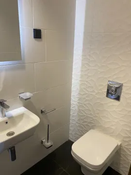 Small bathroom with a washbasin and a wall-hung toilet. - image 12