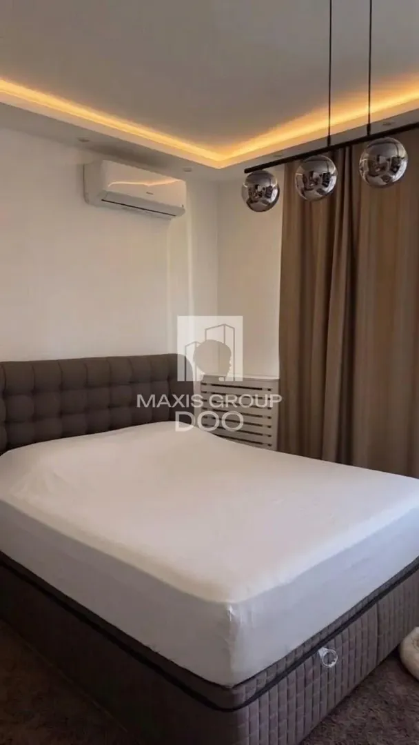 Modern bedroom with a double bed and recessed lighting.