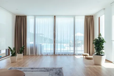 Spacious bright living room with large glass surfaces and a view of the terrace with a swimming pool. - image 8