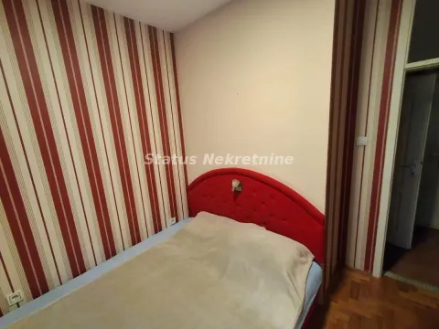 Manja spavaća soba sa krevetom i tapetama na zidu. - image 5