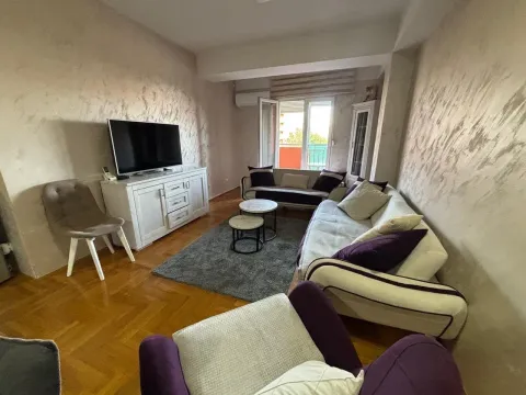 Dnevna soba sa garniturom, televizorom i izlazom na terasu. - image 3