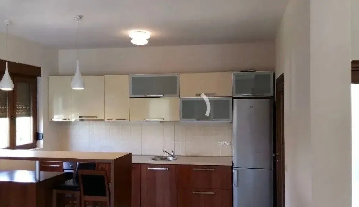 Kitchen with wooden cabinets, sink and refrigerator.