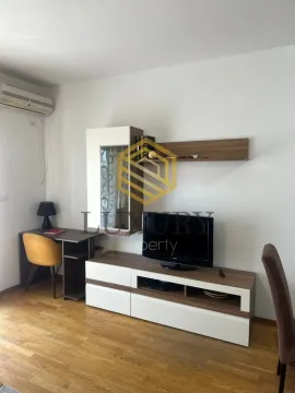 Dnevna soba sa TV komodom, radnim stolom i klima uređajem. - image 2