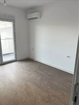 Empty room with laminate flooring, air conditioner, and balcony access. - image 4