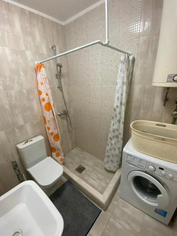 Kompaktno kupatilo sa tuš kabinom, WC šoljom i veš mašinom.