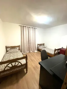 Bedroom with two wooden beds and a desk. - image 4