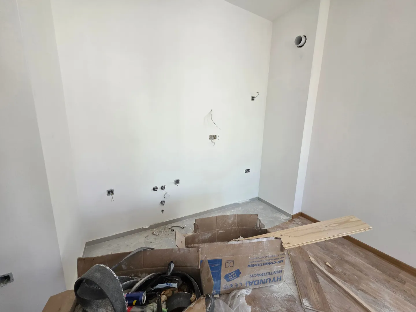 Prazna prostorija u toku renoviranja sa građevinskim materijalom na podu.