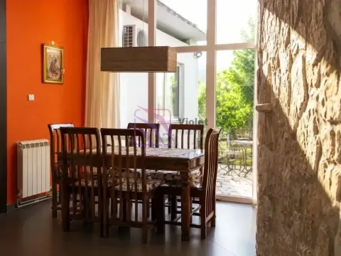 Dining area with a wooden table and chairs by a large window. - image 11