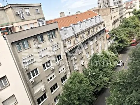 Window view of surrounding buildings and a tree-lined street. - image 13