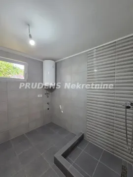 Manje kupatilo sa tuš kabinom i bojlerom na zidu. - image 7