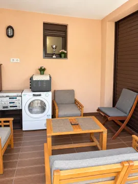 Natkrivena terasa sa garniturom za sedenje, mašinom za pranje veša i audio opremom. - image 2