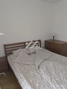 Nameštena spavaća soba sa bračnim krevetom i drvenom komodom. - image 8
