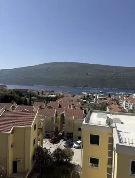 Pogled sa prozora na okolne zgrade, more i planinu. - image 16