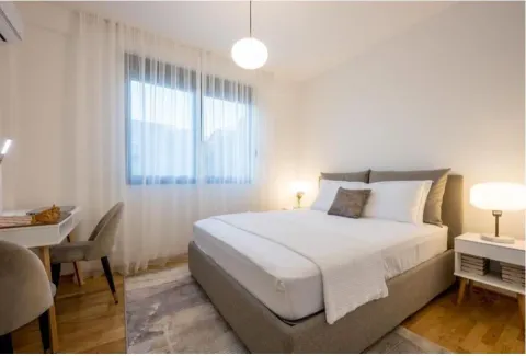 Svijetla spavaća soba sa bračnim krevetom, radnim stolom i noćnim ormarićima. - image 5
