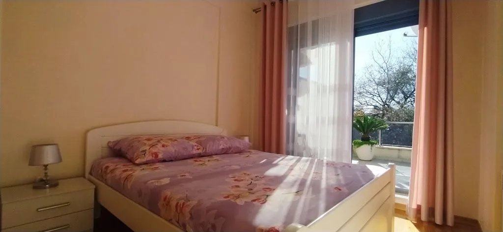 Svijetla spavaća soba sa bračnim krevetom.