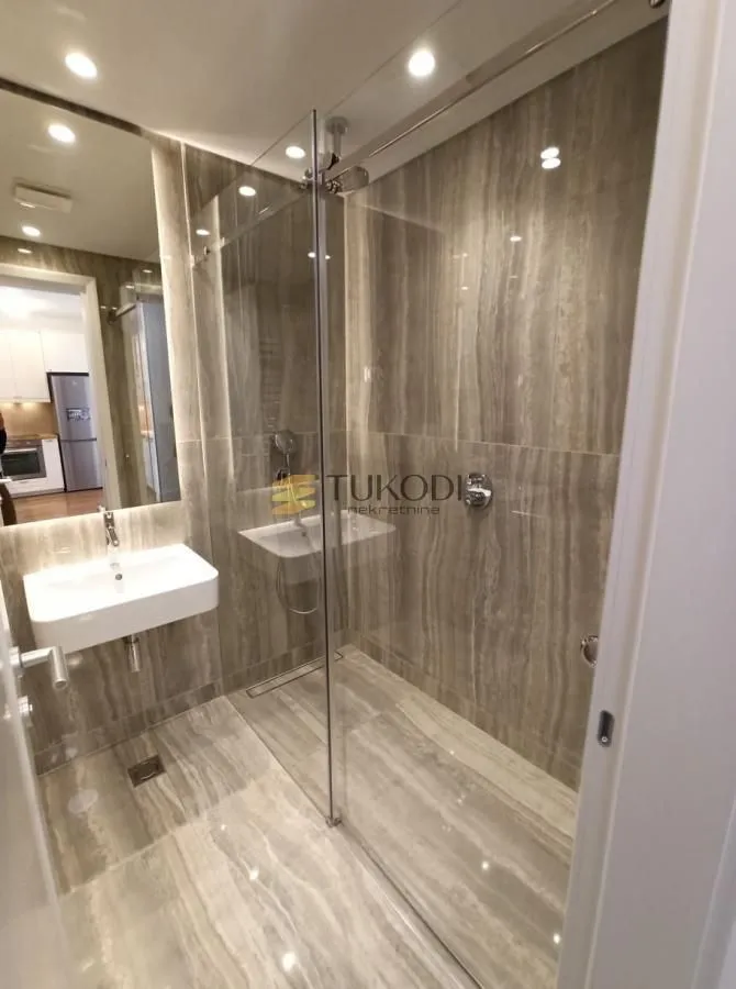 Modernly equipped bathroom with a walk-in shower and washbasin.