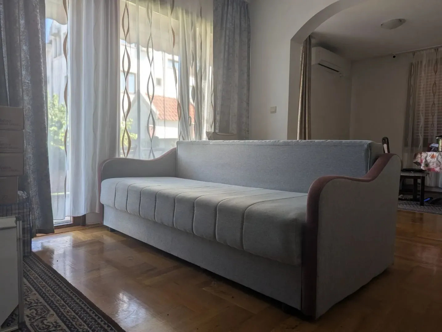 Dnevna soba sa kaučem i pogledom na prozor.