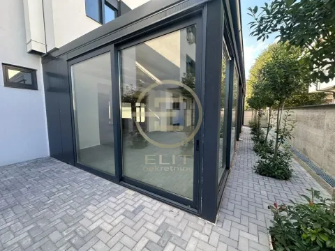 View of the exterior of the building with a paved courtyard and large glass surfaces. - image 9