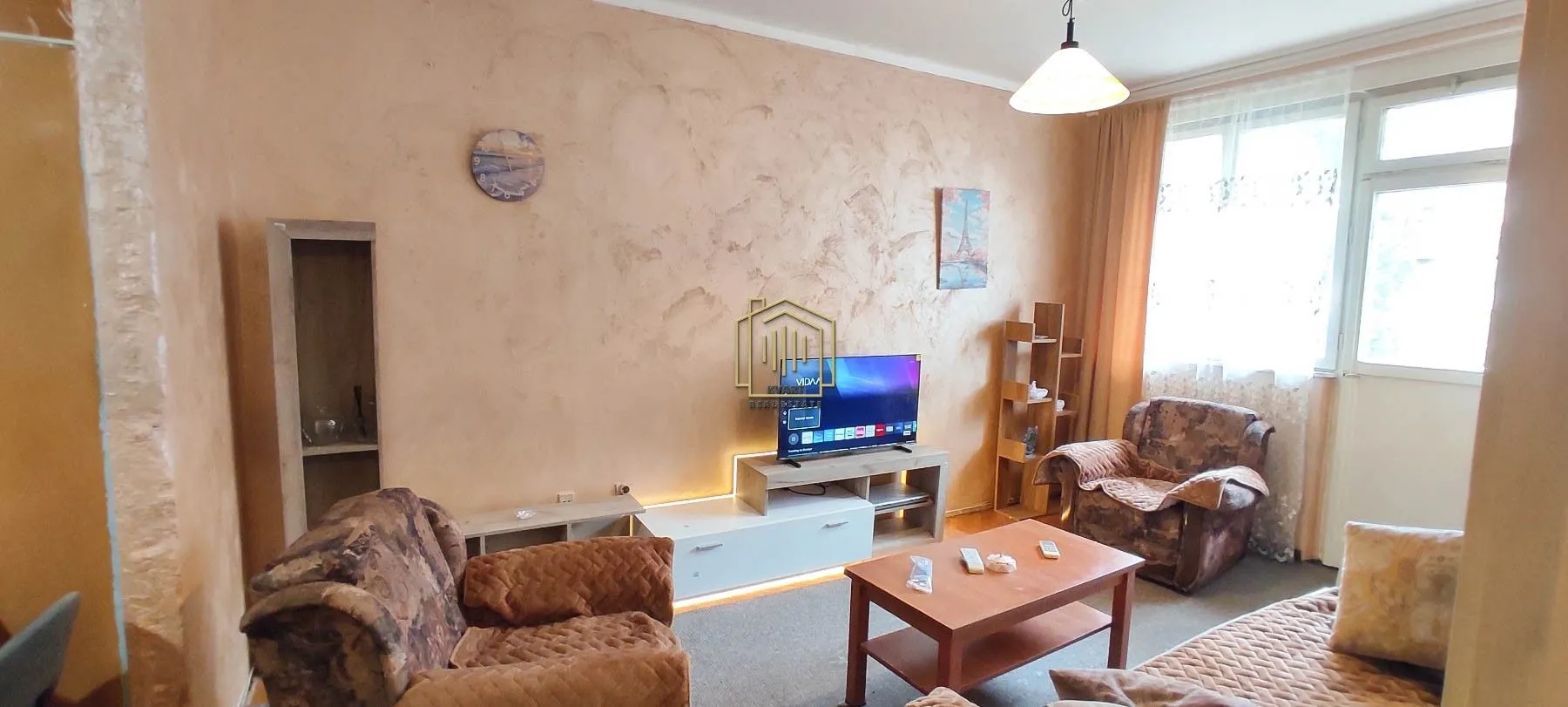 Living room with a sofa set, TV, and coffee table.