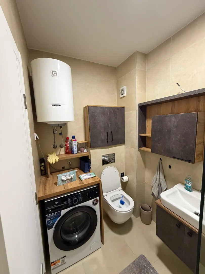 Small bathroom equipped with sanitary fixtures, a sink, and a washing machine.