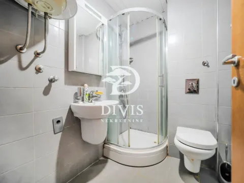 Smaller bathroom with a shower cabin, washbasin, and toilet. - image 3